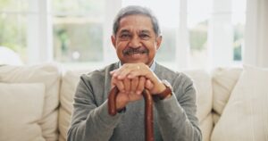 Portrait, senior man and walking stick for Arthritis in elderly care, wellness or health. Happy pensioner, person with a disability and cane for support, balance or movement in retirement home